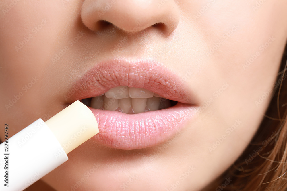 Naklejka premium Beautiful young woman applying lipstick, closeup