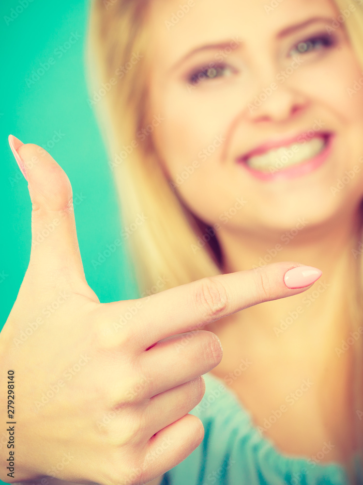 Happy blonde woman pointing with one finger Happy blonde woman pointing with one finger