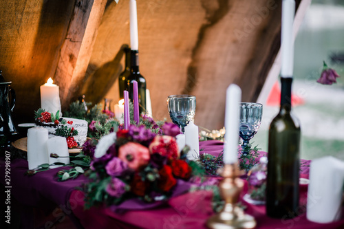 Delicate wedding white cake decorated with pomegranate and succulent surrounded by flowers and candles. photo