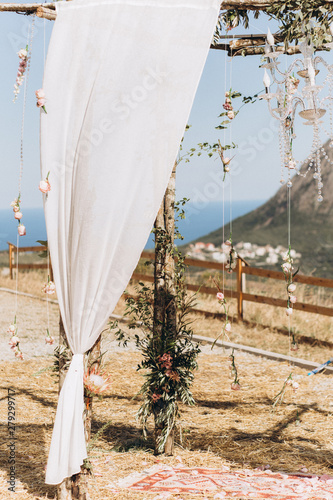 Arch decorated with lively floristics on the background of the sea. Boho style photo