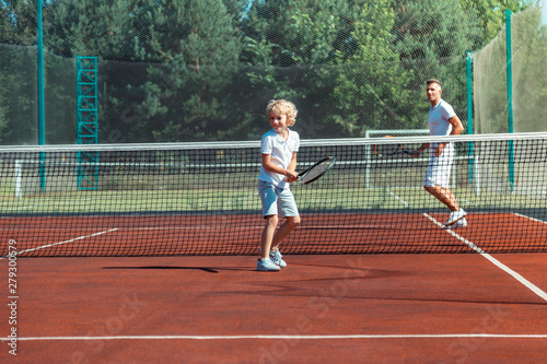 Curly son laughing while playing tennis with daddy © Viacheslav Yakobchuk