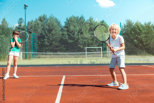 Cheerful brother feeling happy playing tennis with sister © Viacheslav Yakobchuk