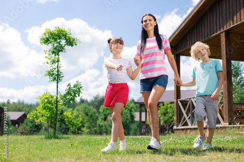 Beautiful woman wearing striped t-shirt walking with children