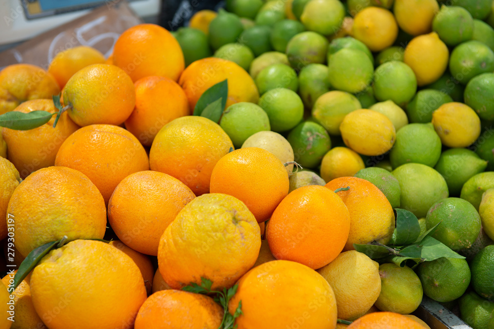 Oranges, lemons and limes in outdoor market. Ripe spanish citrus fruits.