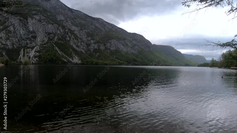 SLOWMO forward moving reveal of lake Bohinj on bad weather day