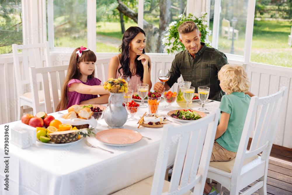 Parents and children eating salads while having lunch outside