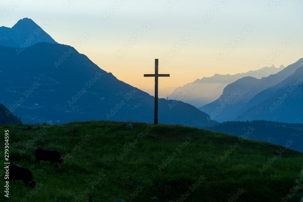 Cross with mountains in the background during sunset
