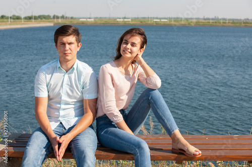 beautiful young couple sitting on a bench in the park
