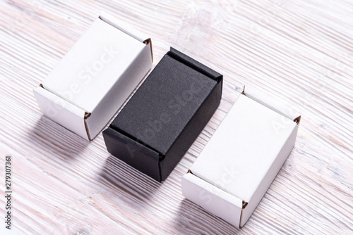 Set of black and white carton boxes on wooden background, top view, flat lay