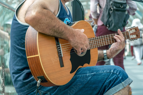A man plays the guitar. Outdoor street portrait. No face, close up. Georgian man