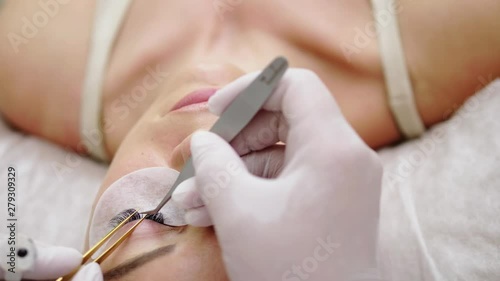 Procedure of eyelash extension in salon by cosmetician