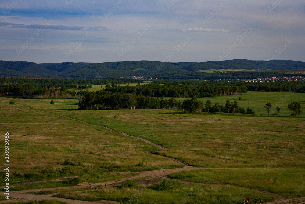 View of the forest in the distance, mountains and meadow.