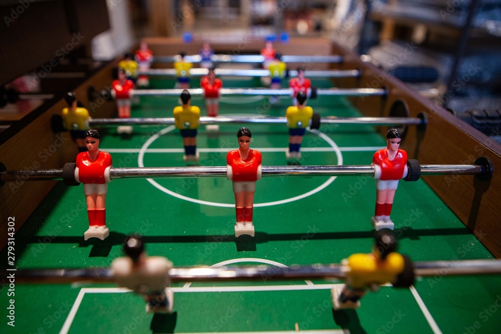 Tabletop football game in bachelor pad. A closeup view of a table football game, typically found in student accommodation, also called foosball, small plastic figures controlled on rods. Tabletop football game in bachelor pad. A closeup view of a table football game, typically found in student accommodation, also called foosball, small plastic figures controlled on rods.