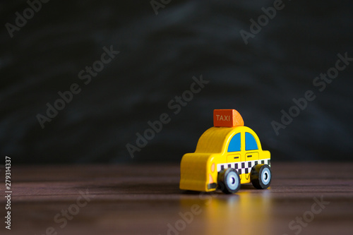 Taxi operator concept. Price of services. Yellow car toy taxi on black background space for text © Svetlana