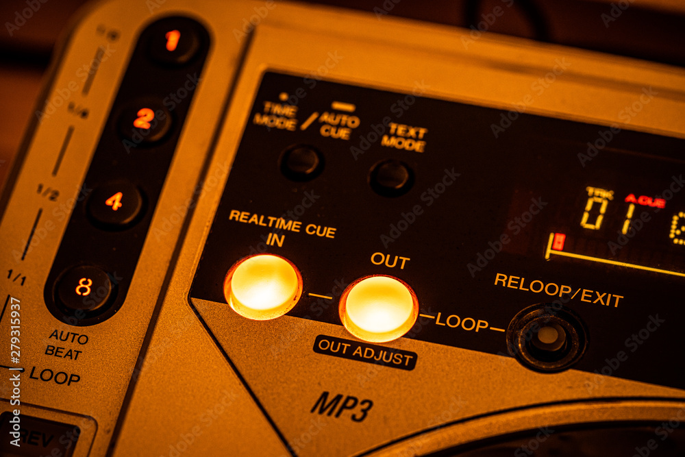 Fototapeta premium Closeup of 'Cue IN/OUT' buttons on a CD Player. Yellow stage lighting.