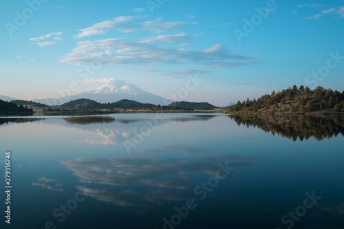 A reflection of snow capped Mount Shasta in a clear water in lake at sunrise in California State, USA. Mount Shasta is a volcano at the southern end of the Cascade Range in Siskiyou County 