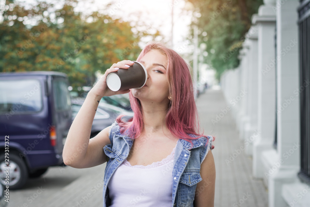 Young stylish woman drinking coffee to go in a city street Young stylish woman drinking coffee to go in a city street