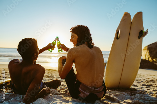 Photography Surfers toasting beers on the beach