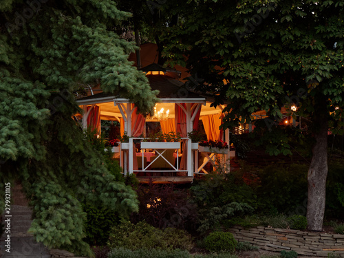 GOMEL, BELARUS Cozy gazebo with lighting in the green thickets in the evening