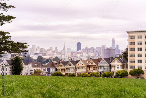 Painted ladies houses and San Francisco downtown on horizon.