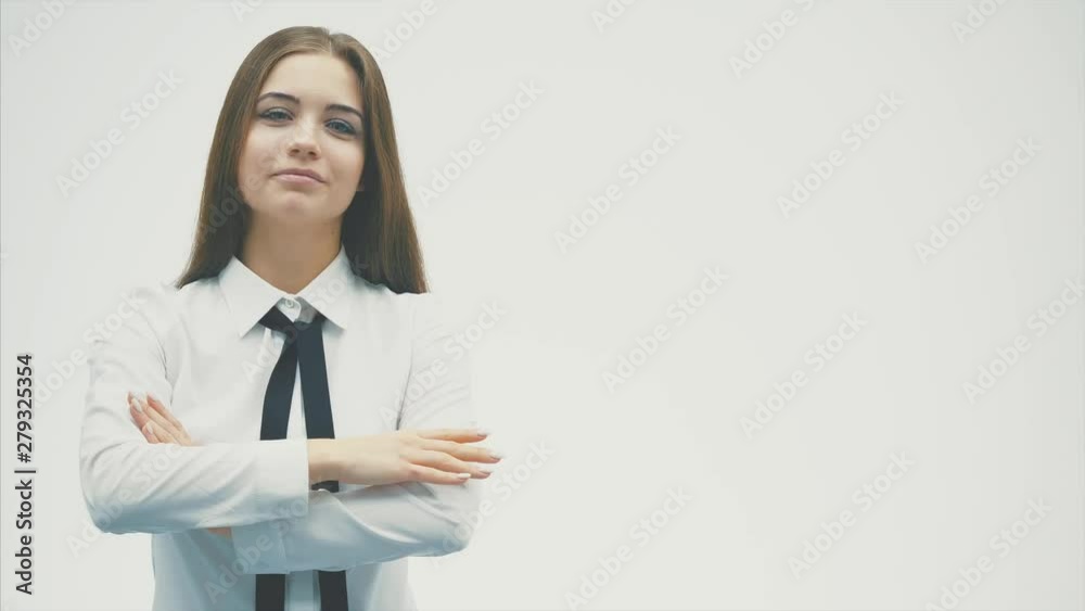 Young pretty business girl standing on a white background. During this, he looks at the camera showing a call gesture. Young pretty business girl standing on a white background. During this, he looks at the camera showing a call gesture.