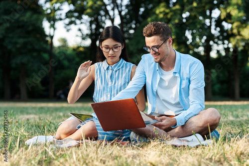 young couple with laptop in the park