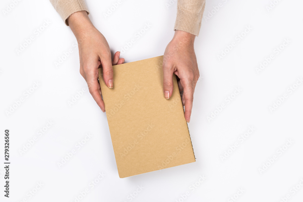 Woman's hands with perfect manicure holding notepad as mockup for your design. White background, flat lay style. Woman's hands with perfect manicure holding notepad as mockup for your design. White background, flat lay style.