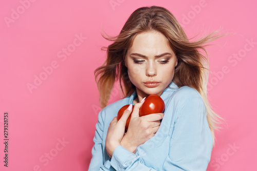 woman with tomatoes on a pink background
