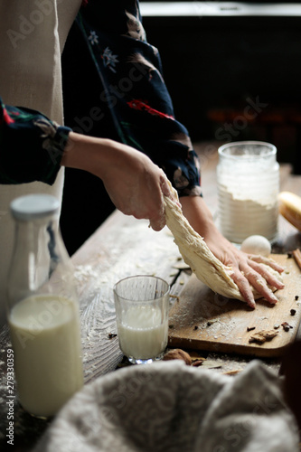 hands making a dough close up rustic style and ingredients for baking around. photo