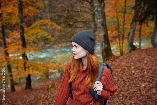 woman in a hat with a backpack in the autumn forest