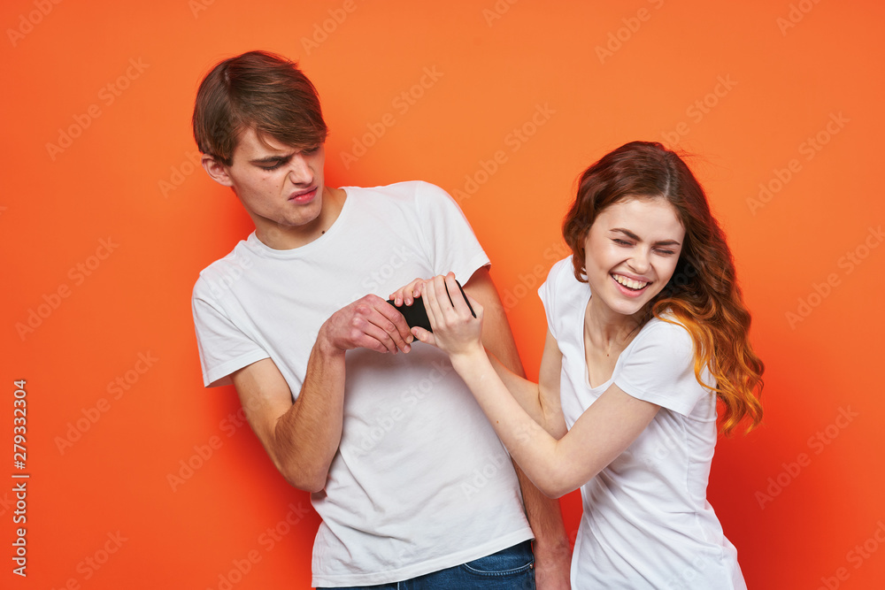man and woman with joystick on orange background man and woman with joystick on orange background