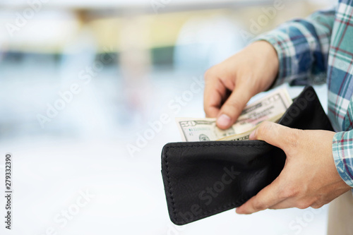 close up Businessman plaid shirt holding an wallet in the hands of an man take money out of pocket. expenses finance concept 