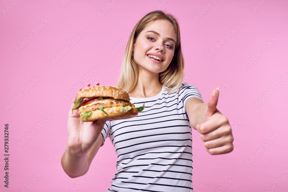 woman with hamburger on pink background woman with hamburger on pink background