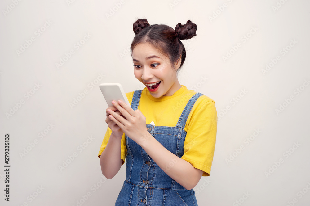 Nice vivid girlish happy smiling girl reading sms notification about winning, isolated over white background Nice vivid girlish happy smiling girl reading sms notification about winning, isolated over white background