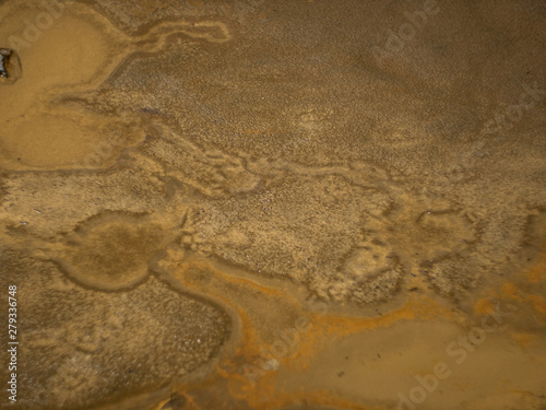 abstract patterns of sand at the bottom of a puddle