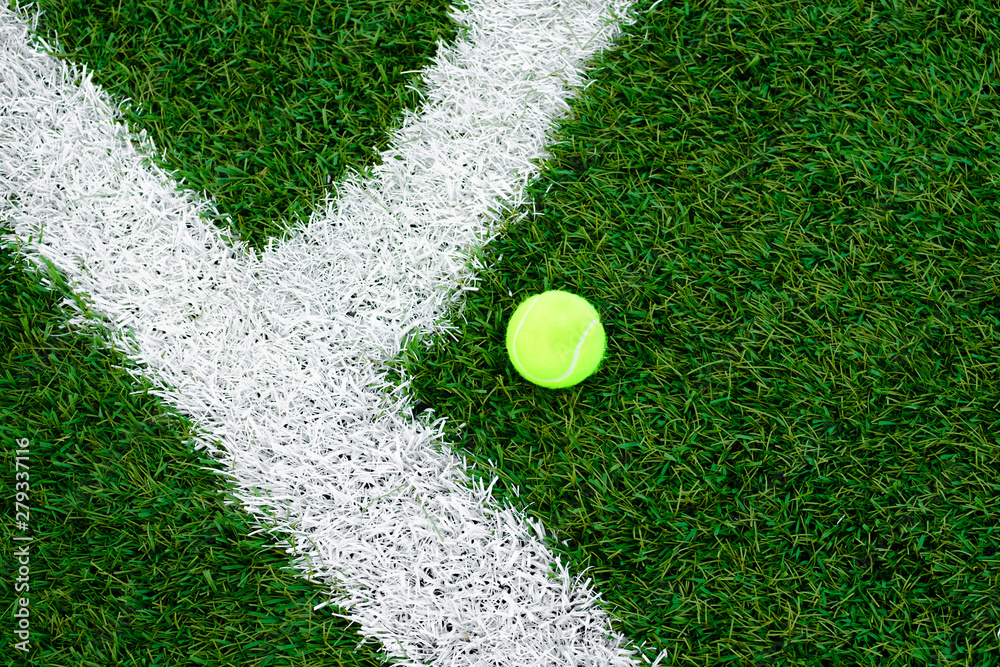 Tennis ball lying on the lawn. artificial turf