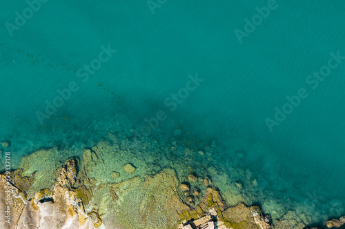 Aerial view of rocky seaside. Rocky stones in the ocean. Aerial photography of beautiful rocky seashore.