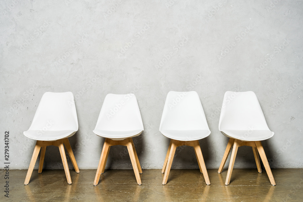 white chairs near grey concrete wall with copy space in office white chairs near grey concrete wall with copy space in office