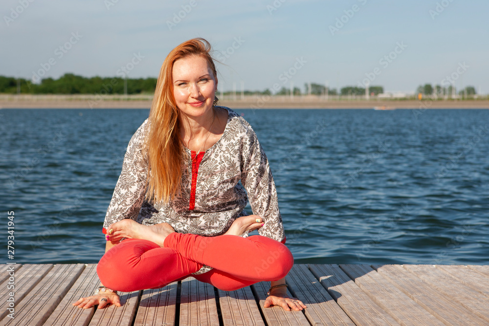 An image of a pretty woman doing yoga at the lake An image of a pretty woman doing yoga at the lake