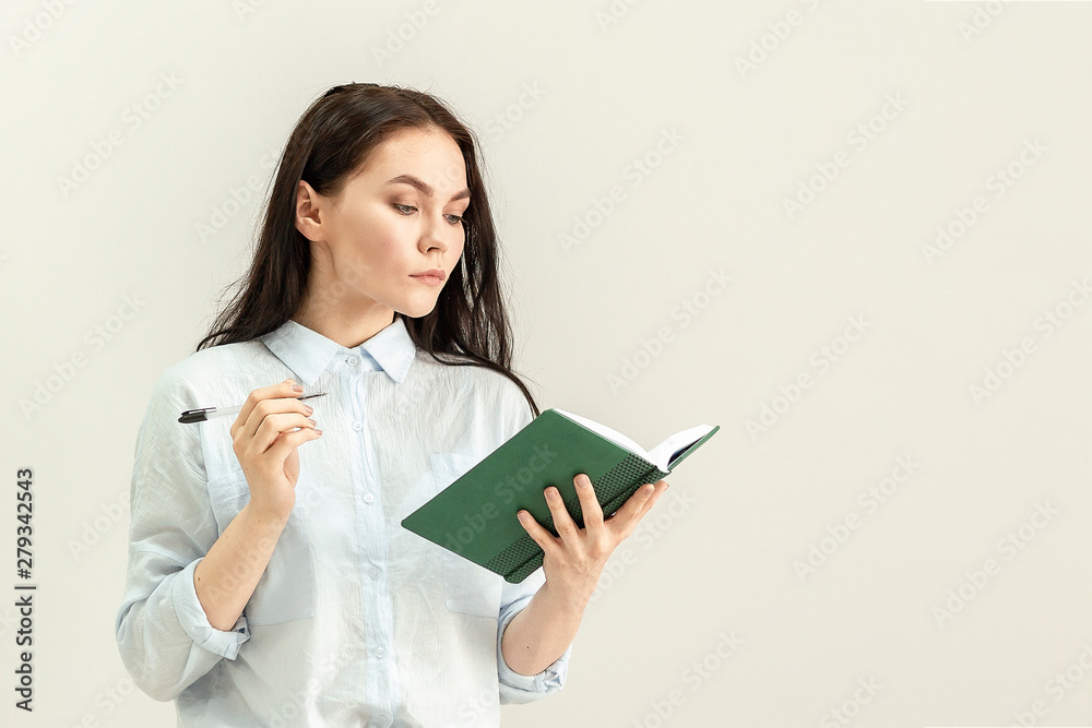 Young beautiful girl with a diary, a notebook and a pen in her hands Young beautiful girl with a diary, a notebook and a pen in her hands