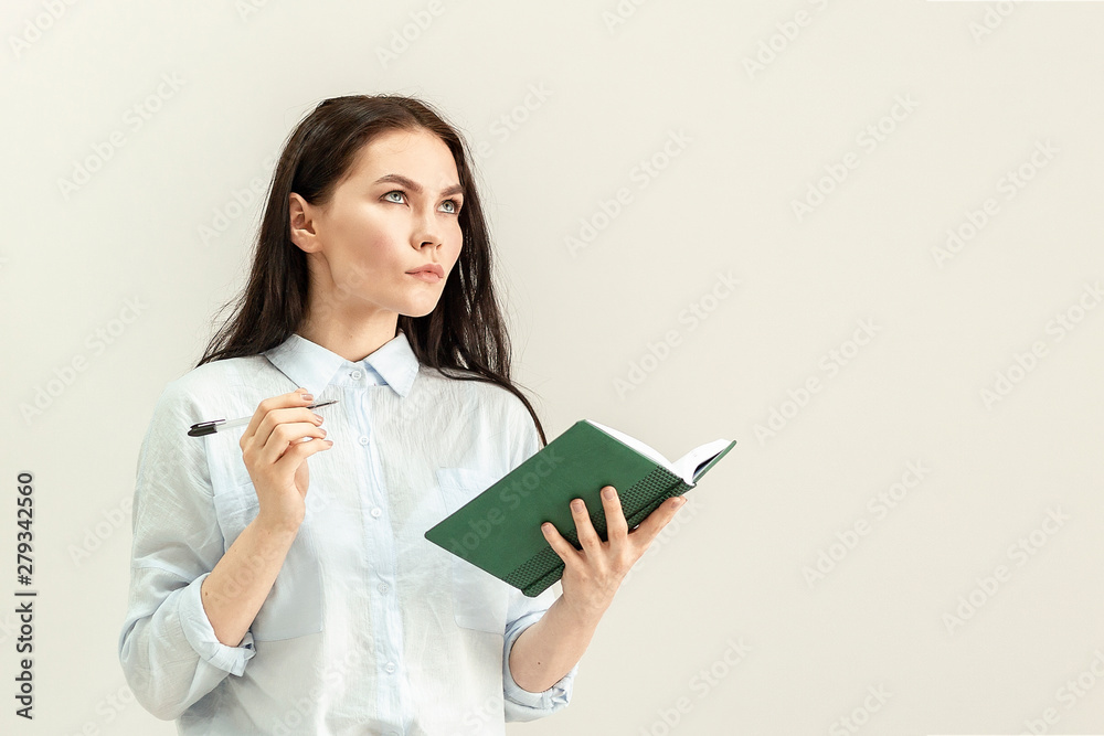 Young beautiful girl with a diary, a notebook and a pen in her hands Young beautiful girl with a diary, a notebook and a pen in her hands