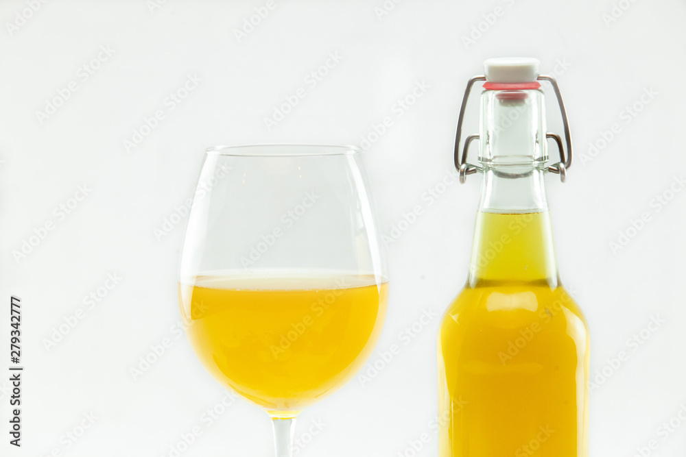 Organic & healthy homebrew mushroom tea. Freshly blended Manchurian mushroom tea is seen closeup, in a glass bottle and stemmed glass, isolated against a white background. Versatile health drink. Organic & healthy homebrew mushroom tea. Freshly blended Manchurian mushroom tea is seen closeup, in a glass bottle and stemmed glass, isolated against a white background. Versatile health drink.
