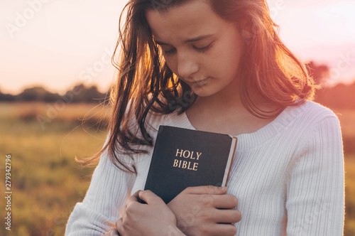 Fototapet Christian teenage girl holds bible in her hands