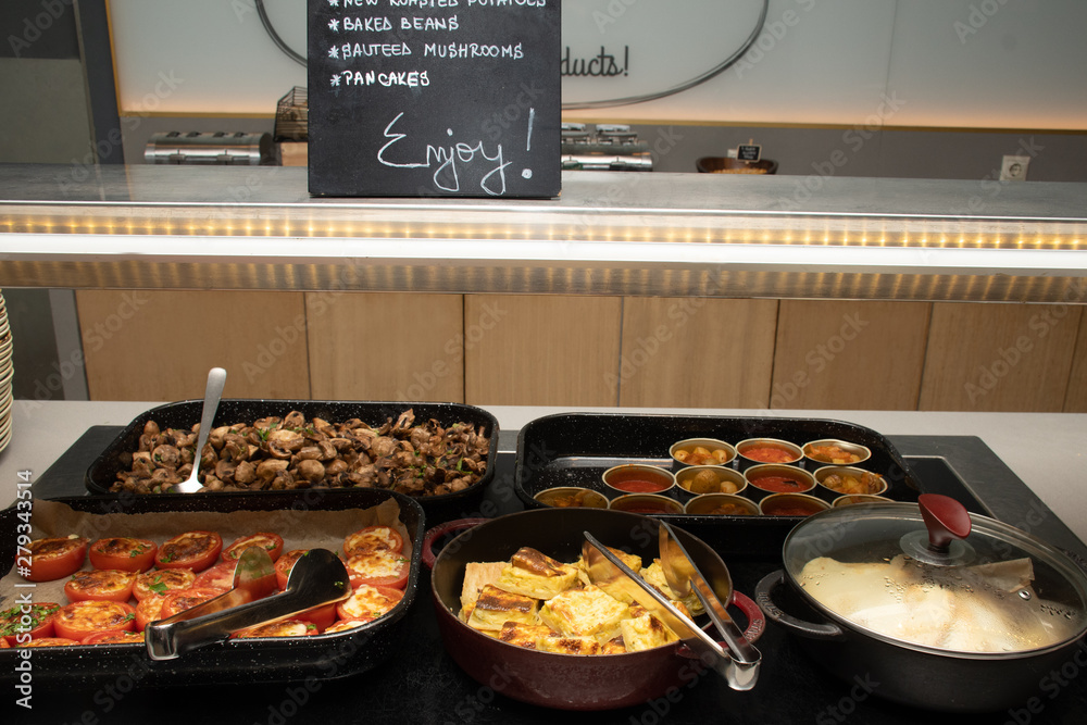 Selection of self service catering continental breakfast buffet display,  catering brunch table food buffet filled with delicious food, grill, bacon,  eggs, hot station in a hotel or restaurant setting Stock Photo
