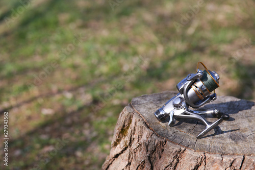 background of silver fishing reel on the stump with copy space. © Петр Смагин