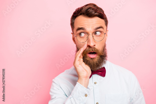 Close-up portrait of concentrated hiding from public and strangers shy reserved youngster holding cupped palm near mouth isolated pastel background