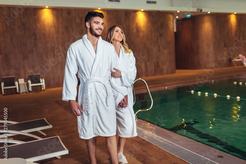 Happy young couple enjoying treatments and relaxing at wellness spa center