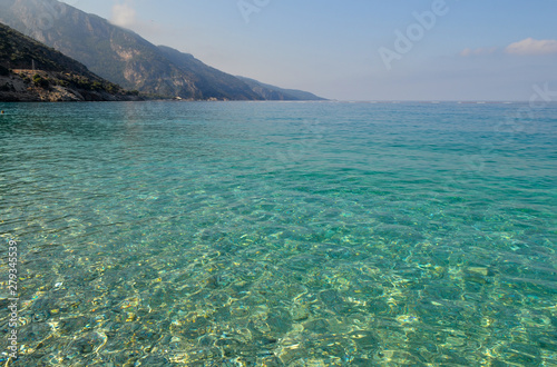 Beautiful seascape. Calm sea with clear water. With mountain and blue sky