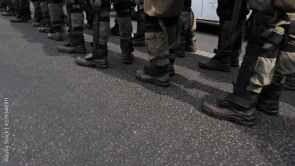 A detachment of soldiers built in one line. Special police unit in anticipation of the order of the commander. Soldiers in green camouflage, body armor and black boots. The military defend the borders A detachment of soldiers built in one line. Special police unit in anticipation of the order of the commander. Soldiers in green camouflage, body armor and black boots. The military defend the borders