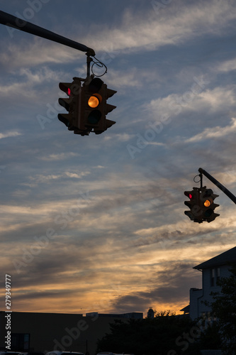 Traffic light with yellow light against the evening sky in USA.  Selective focus.